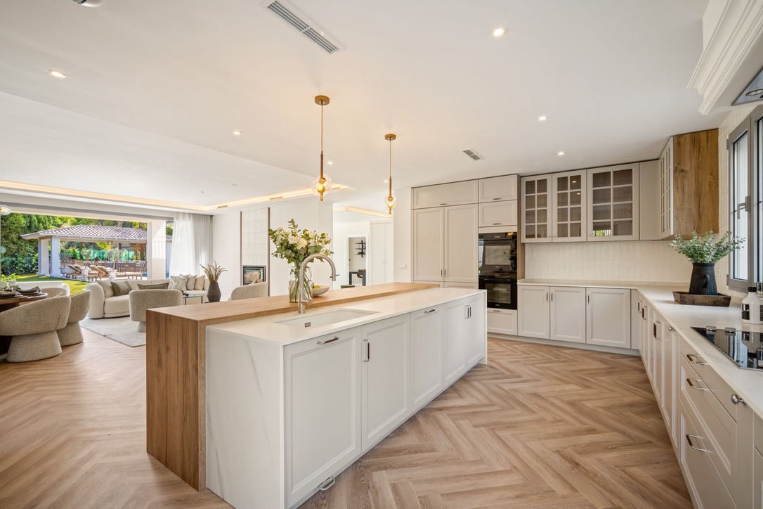 Open-plan kitchen with a marble and oak island in the Los Arqueros villa