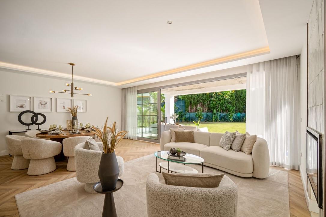 Open living and dining room with herringbone oak floors opening onto the garden